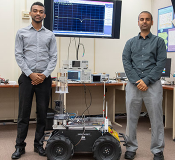 U.S. Army Research Laboratory scientists Dr. Fikadu Dagefu and Gunjan Verma pose with one of the robots used to validate a new algorithm they developed.