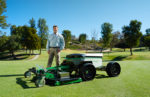 Man standing in a field with a Graze mower