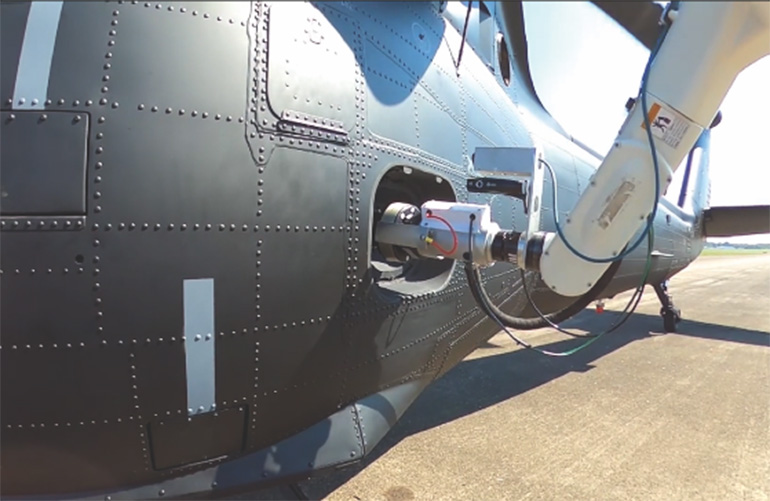 a stratom robot arm refuels a helicopter