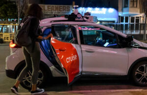 cruise robotaxi picks up passengers on a sidewalk