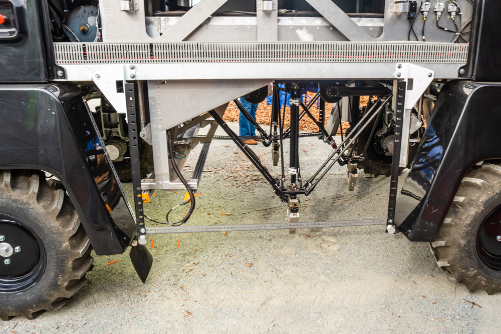three delts style robot arms underneath the carriage of the robotic vehicle.