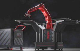 A red industrial robot arm sitting on a mobile black box base on against a black background.