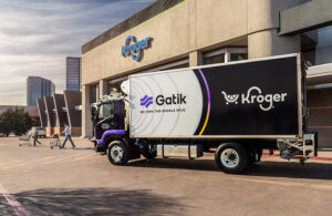 Gatik medium-duty truck with Kroger branding in front of a Kroger store.