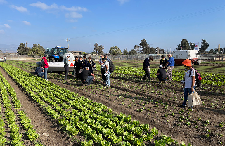 show visitors in a field inspecting the accuracy of a demonstration.