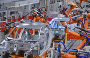 industrial robots putting together cars on a factory line.