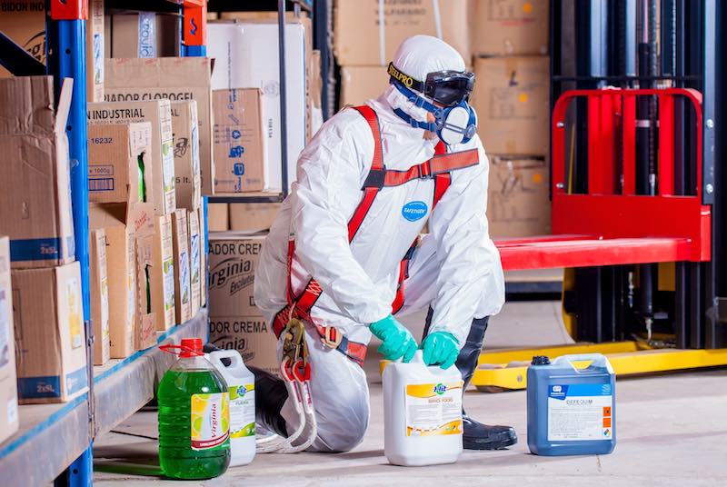 a human wears a hazard suit while working with hazardous chemicals