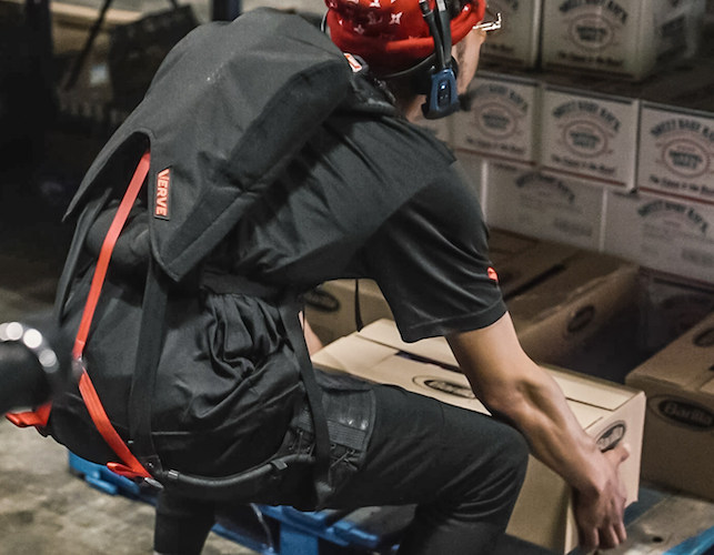 a warehouse employee lifting a box with the help of Verve Motion's soft exoskeleton.