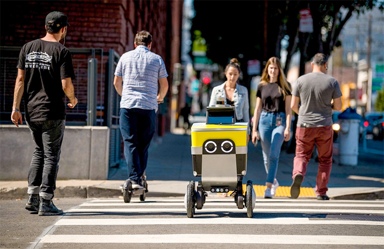 a Serve mobile robot crosses the street on a crosswalk.