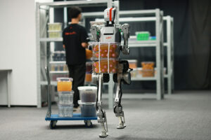 LimX humanoid robot moves a tote in a warehouse.