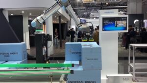 A UR20 cobot arm from Universal Robots performing a palletizing demo at a tradeshow in China.