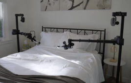 Two Stretch robots from Hello Robot on either side of a white bed, both with their arms reaching across the bed in the University of Illinois study.