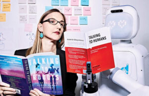 Andrea Thomaz holding a book called "Talking to Robots" standing next to a Moxie robot holding a "Talking to Humans" book, as Diligent Robotics announces its AI Advisory Board.
