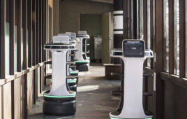 Bear Robotics' Servi Plus robots driving down a hallway.