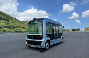 WeRide's autonomous minibus, a boxy vehicle, on an empty road.
