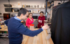 WPI researchers interacting with their origami-inspired robotic arm.