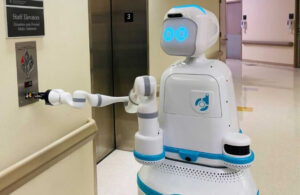 Diligent Robotics' Moxi robot pushing an elevator button.