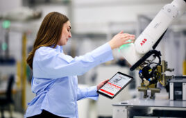 A woman operating a robot with the help of ABB's RoboMasters.