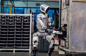 Boston Dynamics' Atlas robot grabbing an automotive part. The Hyundai unit said in April 2025 that it plans to produce thousands of humanoids.