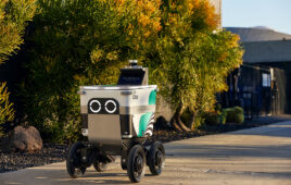 A Serve sidewalk delivery robot rolling down a sidewalk.