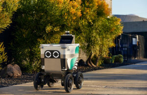 A Serve sidewalk delivery robot rolling down a sidewalk. The company announced expansion plans in April 2025.