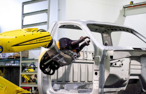 A FANUC robot working in car manufacturing.