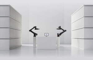Two Standard Bot robot arms in a white room.