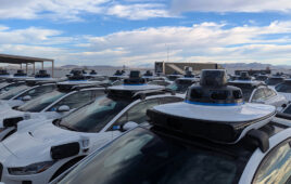 A lot full of Waymo self driving vehicles.