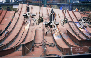 Legged robots on a HD Hyundai shipbuilding site, rendered by NEURA Robotics.