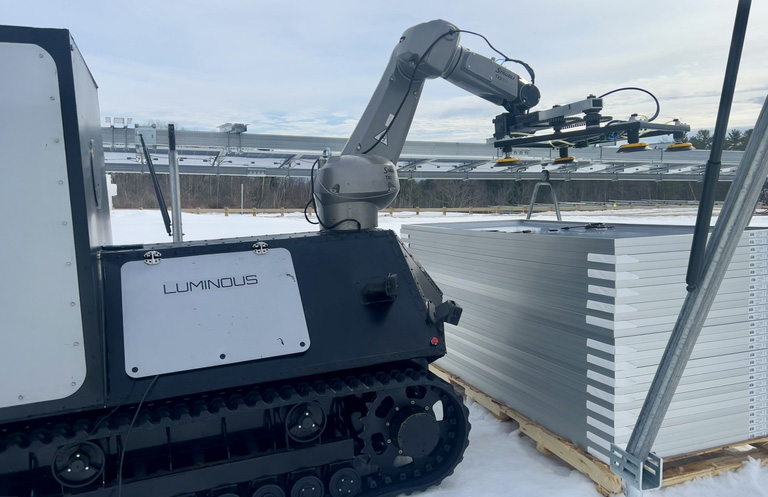 The LUMI robot lifts solar panels from pallets.