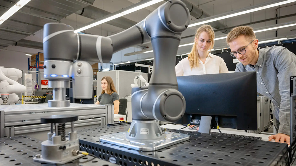 Alessandro Melone, Robin Kirschner and Kübra Karacan in a lab with robots that they classified as part of the "Tree of Robots."