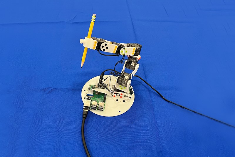 a robot arm holding a pencil at MIT.