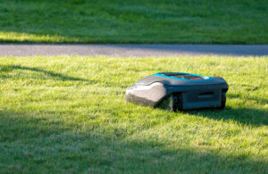 A robotic lawnmower mowing green grass.
