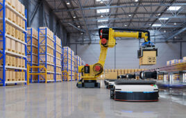 A robotic arm placing a box on an AMR.