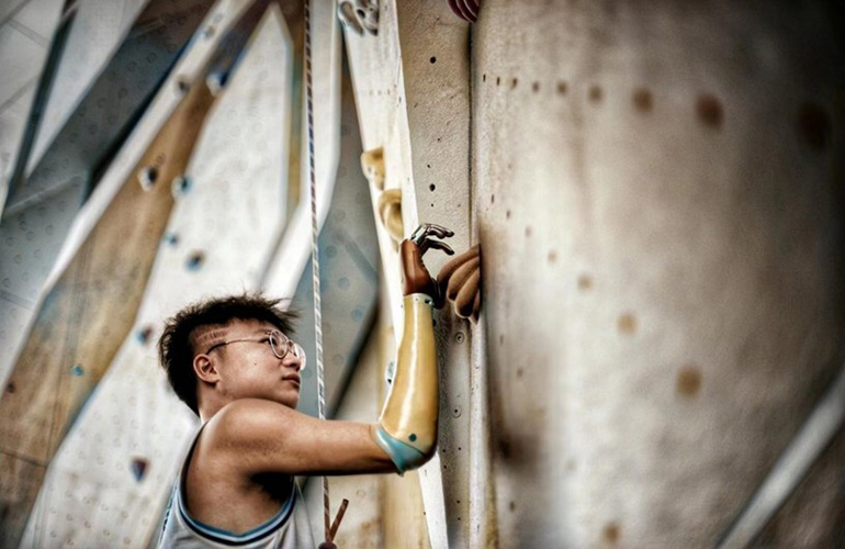 Jian climbing in a climbing gym.