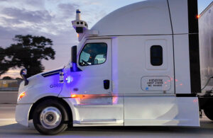 view of the truck cab from the perspective of an auto next to the truck, clearing showing the absence of a driver.