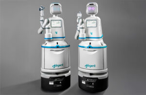Two Moxi robots in a grey room.