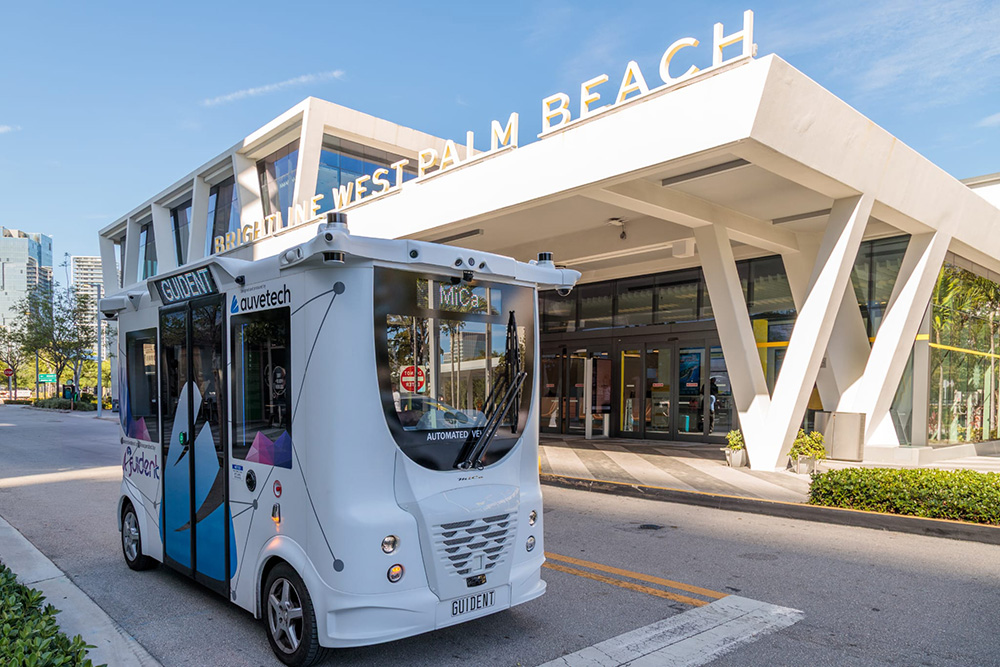 auvetech shuttle parked on curb outside a building.