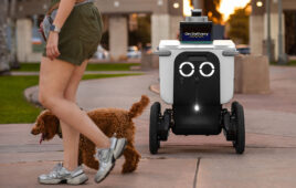 Serve Robotics delivery robot with a woman and dog walking by.