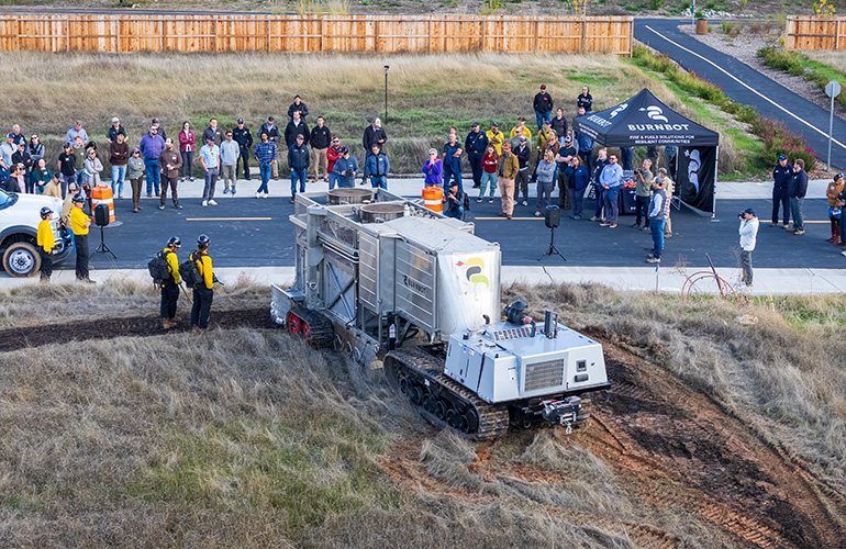 drone image of a burnbot robot demo in front of a crowd in grass valley.