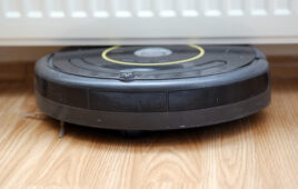 A robotic vacuum cleaner stuck under a radiator. iRobot will continue as a consumer brand despite bankruptcy proceedings.