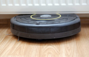 A robotic vacuum cleaner stuck under a radiator. iRobot will continue as a consumer brand despite bankruptcy proceedings in December 2025.