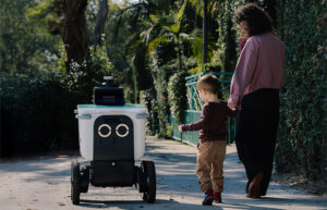 A delivery robot from Serve Robotics with a child and parent. The company's CEO says AI and robotics should delight people.