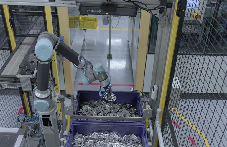 A UR5 cobot from Universal Robots uses strain wave gearing for fluid robot motion in material handling.