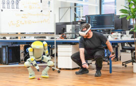 sprout squats next to an operator with a VR headset.