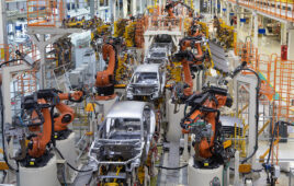 Robots working on a car in a factory.