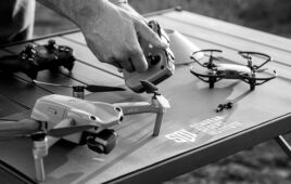 image of hands and drones on a table with SDI logo.