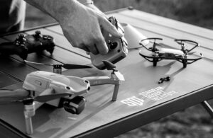 image of hands and drones on a table with SDI logo.