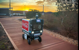 hero image of the ottobot delivery robot at sunset, driving along a sidewalk.
