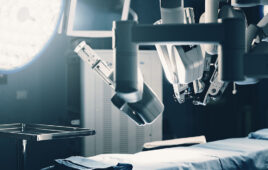 A surgical robot resting above a bed.