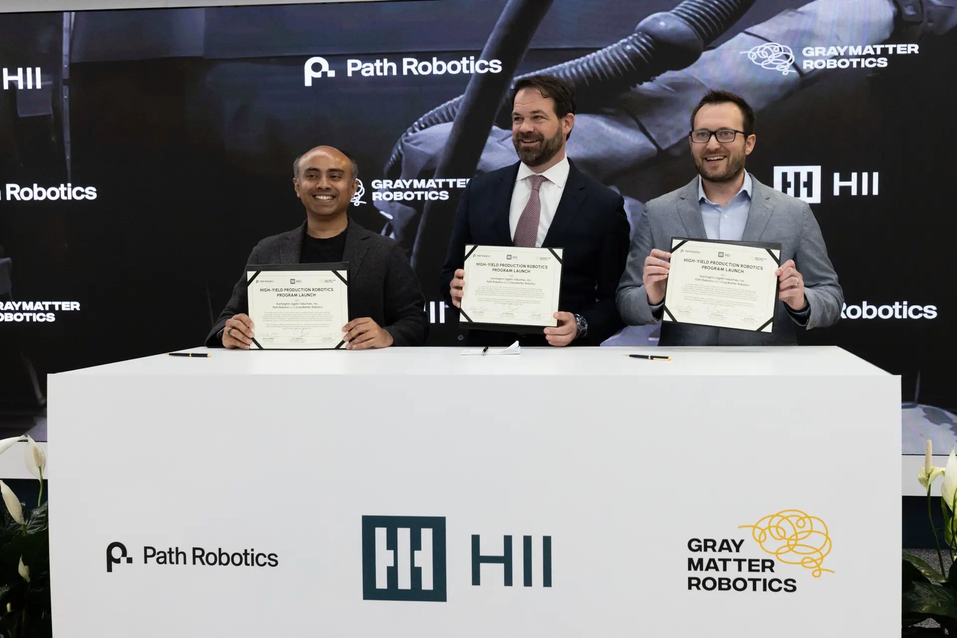 From left to right: Ariyan Kabir, GrayMatter Robotics CEO and co-founder, Eric Chewning, executive vice president of maritime systems and corporate strategy at HII, and Andy Lonsberry, Path Robotics CEO and co-founder. 